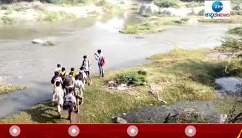 Children crossing brook to go to School in Raichuru