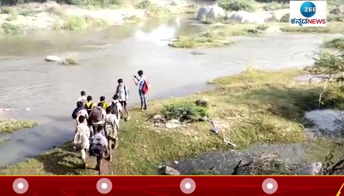 Children crossing brook to go to School in Raichuru